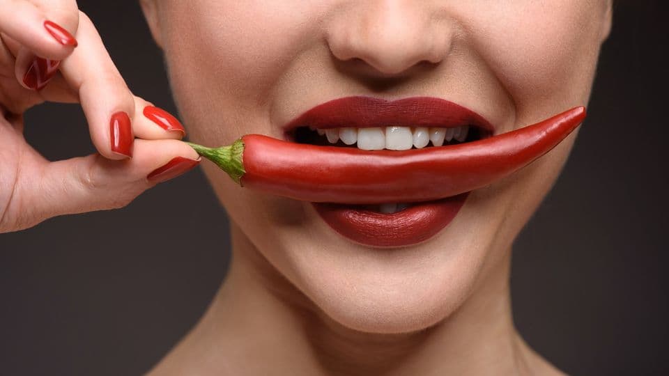 chili im Mund einer Frau, Sex anmache
Close up of sexy young girl biting spicy red pepper with desire