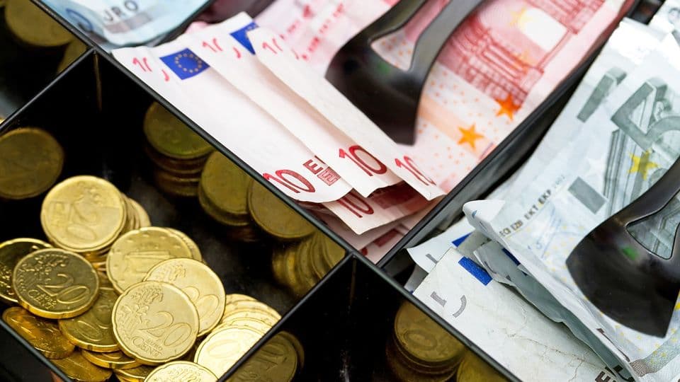 Kasse mit Euro-scheinen und Münzen