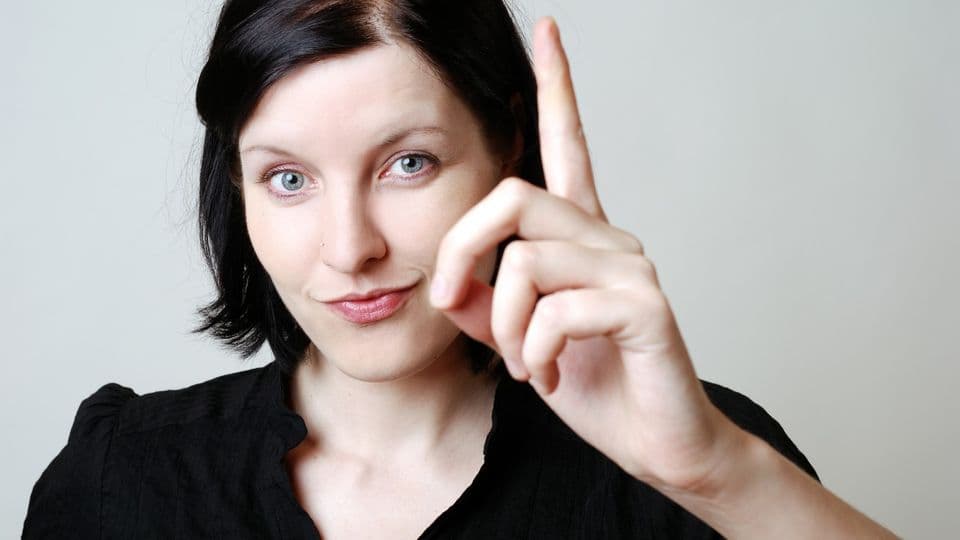Frau erhebt ihren Zeigefinger