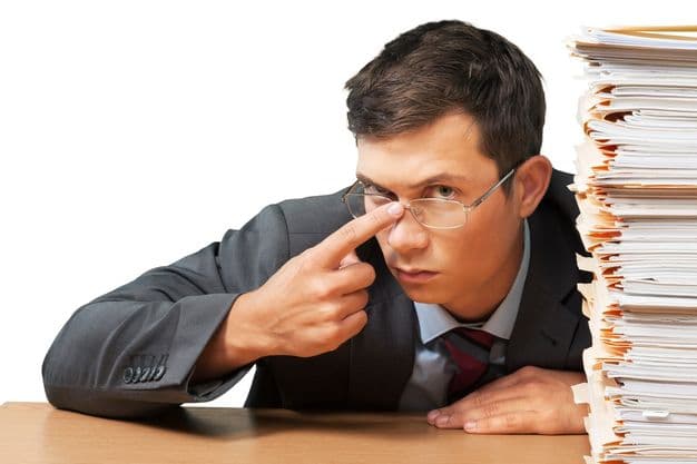 Verwunderter Angestellter am Schreibtisch mit Akten