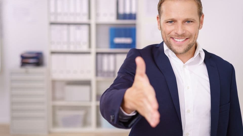 mann im büro reicht die hand zur begrüßung