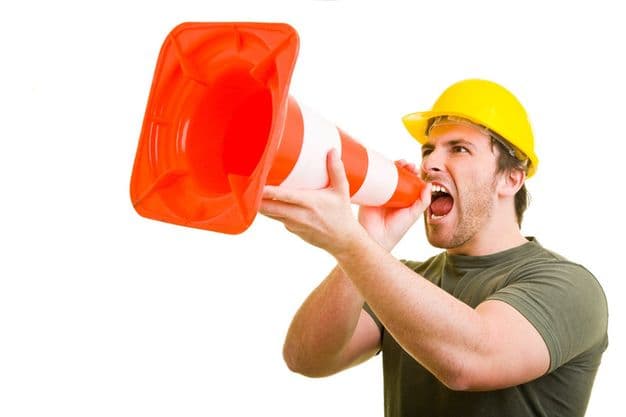 Bauarbeiter schreit in ein Pylon