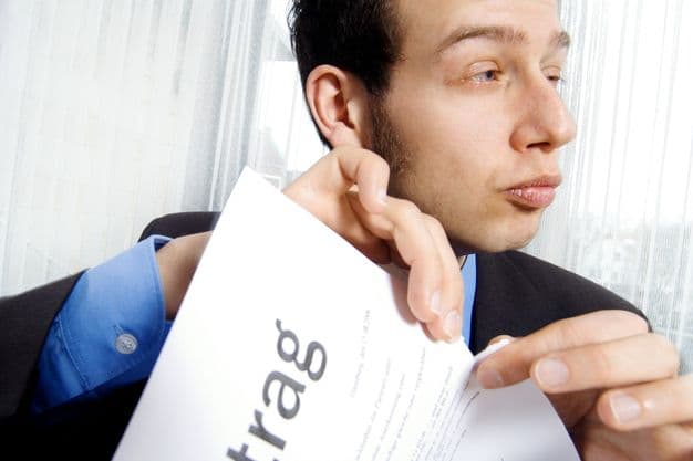 Mann im Anzug zerreist Vertrag.