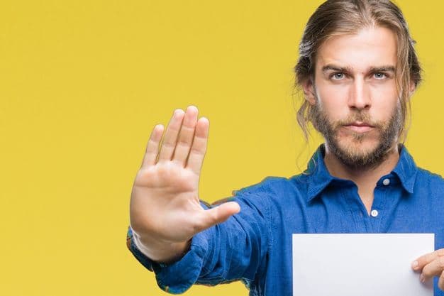 Young handsome man with long hair over isolated background holding blank paper with open hand doing stop sign with serious and confident expression, defense gesture
Junger Mann steht vor einem gelben Hintergrund und hat ein Blatt papier in der Hand – mit