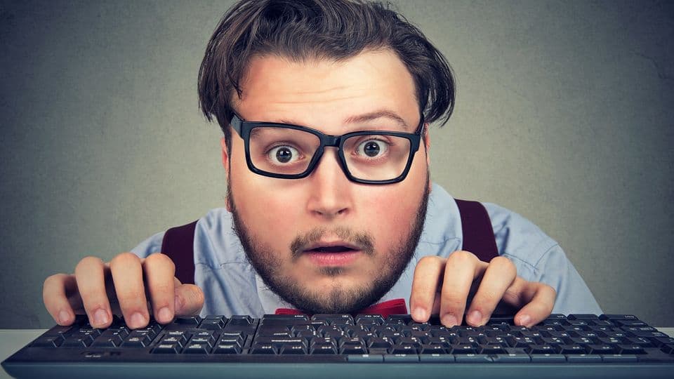 Surprised business man typing on key board looking amazed