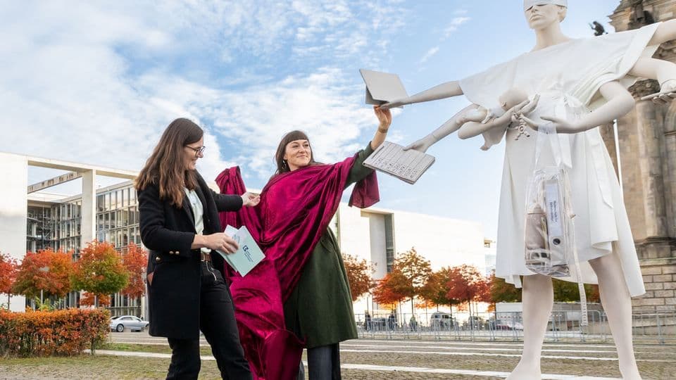 Justitia ohne Mutterschutz: Johanna Röh und Stefanie Gornicki enthüllen die Skulptur vor dem Bundestag.