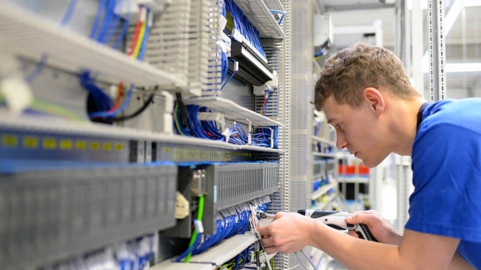 Elektriker montiert Schaltschrank in der Industrie