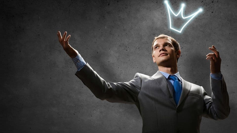 Anzugträger mit leuchtender Krone auf dem Kopf