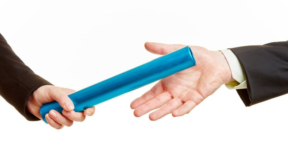 Zwei Geschäftsleute bei der Übergabe vom Staffelstab beim Staffellauf