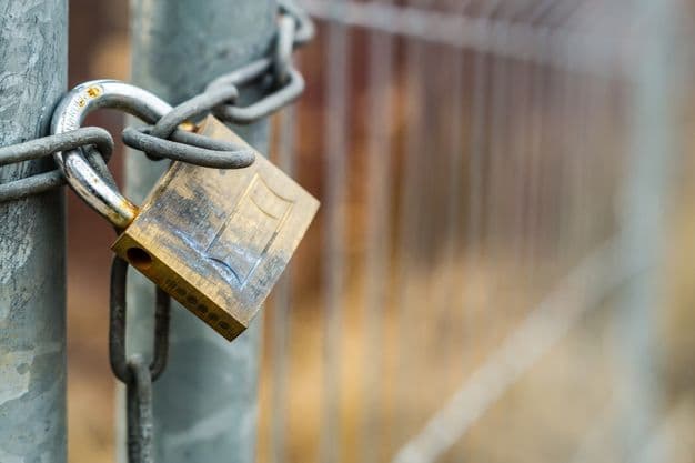 Bauzaun mit Vorhängeschloss verschlossen.