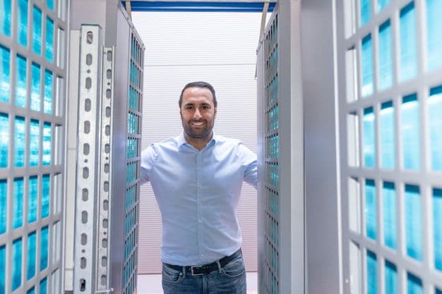 Handwerksunternehmer Ahmet Düman mit einer 50-Kilowatt-Variante der mobilen Wärmepumpe. Blitzlicht lässt die Lamellen der Wärmetauscher blau aufleuchten.