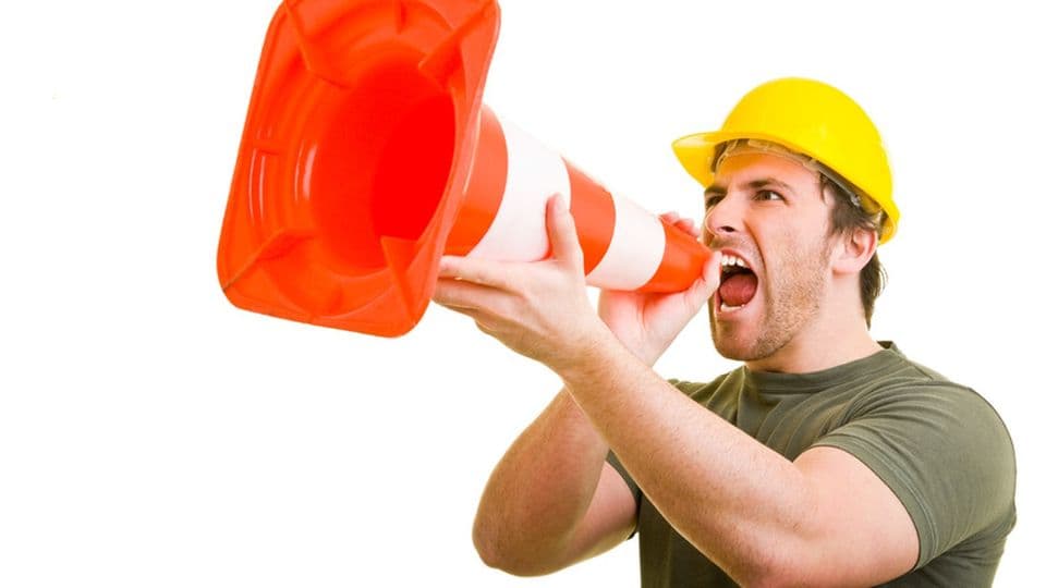 Bauarbeiter schreit in ein Pylon